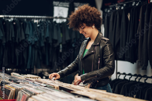 Woman with afro hair browsing vinyl records in a record store