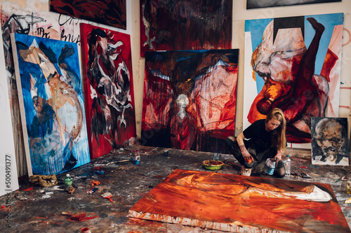Fototapeta Naklejka Na Ścianę i Meble -  Female painter artist painting and creating her art in a creative studio