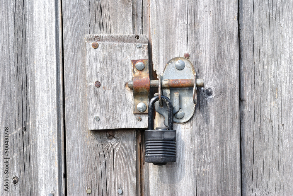 Old Timber Door with Metal Padlock and Bolt in Close Up Old Timber Door with Metal Padlock and Bolt in Close Up