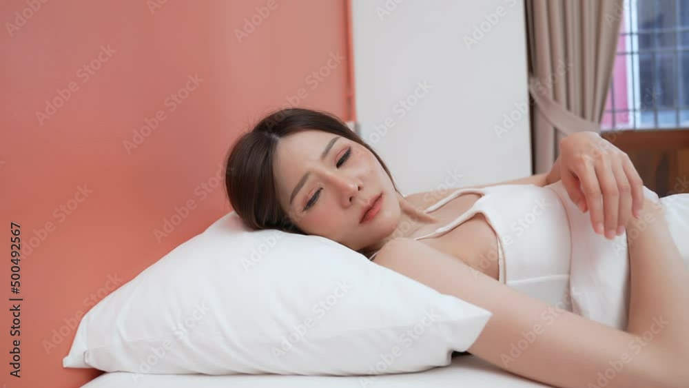Holiday concept of 4k Resolution. Asian girls don't want to get out of bed in the morning. Mobile phone alarm. Laziness in waking up. Holiday concept of 4k Resolution. Asian girls don't want to get out of bed in the morning. Mobile phone alarm. Laziness in waking up.