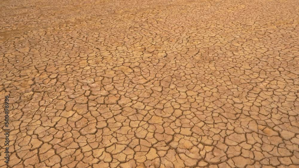 AERIAL: Aerial view of cracked land caused by long draught. Brown desiccated soil with ground cracks and no vegetation. Dry landscape with crack pattern caused by lack of water. AERIAL: Aerial view of cracked land caused by long draught. Brown desiccated soil with ground cracks and no vegetation. Dry landscape with crack pattern caused by lack of water.