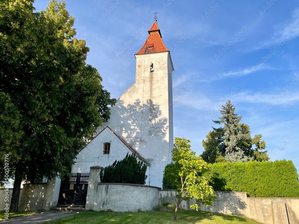 Fototapeta premium Church of the Nativity of St. John the Baptist, built in Romanesque style with a Baroque extension. In the village of Hovorcovice near Prague. High quality photo