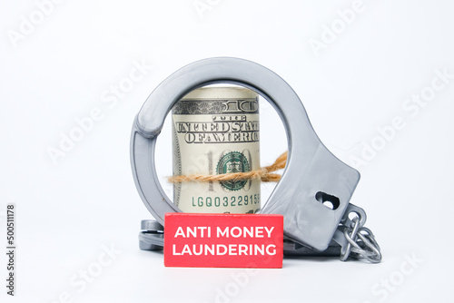Canvas Print A picture of fake money, handcuff and anti money laundering on red wood block
