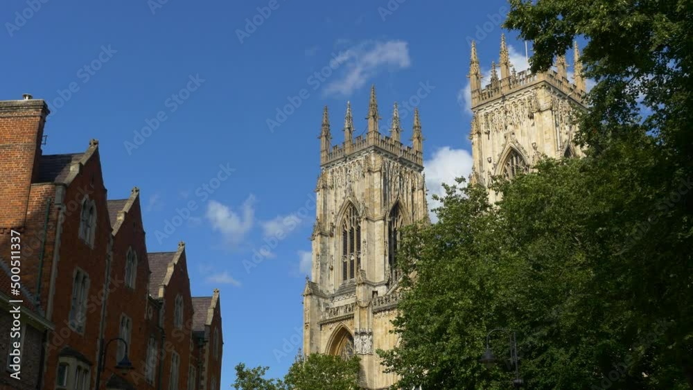 The Western towers of York Minster in sunshine. Trees in foreground The Western towers of York Minster in sunshine. Trees in foreground