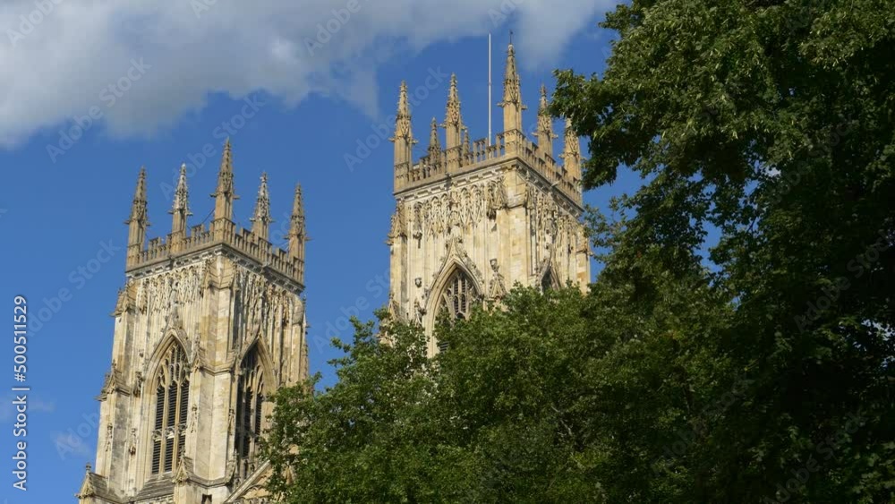 The Western towers of York Minster in sunshine. Trees in foreground The Western towers of York Minster in sunshine. Trees in foreground