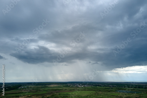 Landscape of dark clouds forming on stormy sky during thunderstorm over rural area © bilanol