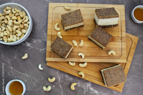 Crunchy cashew nuts  and homemade chocolate Bajadera cookies on wooden board. photo