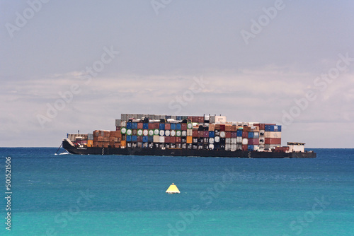 Importing of an overloaded inter-island container ship off Honolulu Harbor in Hawaii