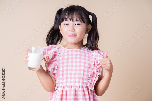 Image of Asian child drinking milk on background