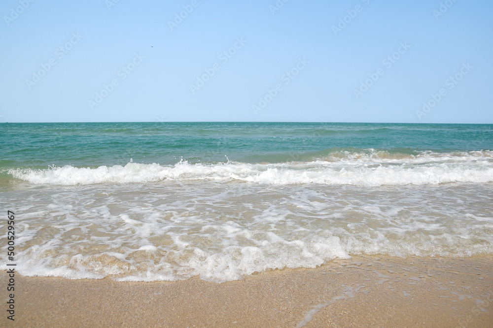 Wide angle shot of sea water hitting the beach, white sponge of the sea, summer nature background image concept.