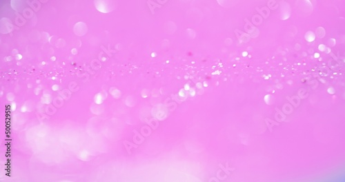 Bokeh light overlay. Blur glow. Sequin reflection. Defocused white shiny circles glare on pastel pink color glamour abstract background.