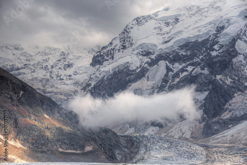 Mountain landscape with soft focus. A small cloud hangs in a mountain valley above a glacier.