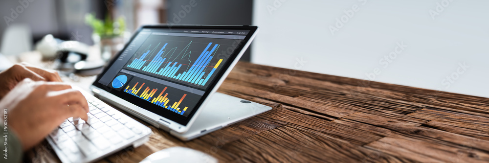 Businessperson Pointing At Graph On Digital Laptop Businessperson Pointing At Graph On Digital Laptop