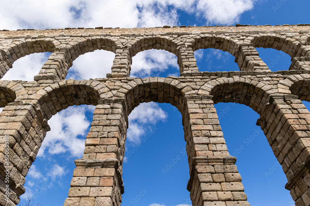 aqueduct of Roman antiquity in Segovia with tourists walking under its arches in Segovia aqueduct of Roman antiquity in Segovia with tourists walking under its arches in Segovia