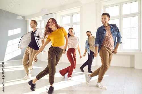 Fototapeta Naklejka Na Ścianę i Meble -  Group of happy beautiful young people enjoying a contemporary dancing class. Team of cheerful smiling dancers in casual wear practising a new choreo and having a good time together in a modern studio