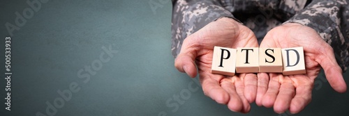 Male Soldier Holding Wooden Cubes With PTSD Text