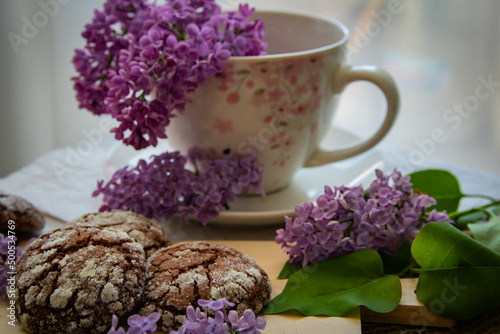 Romantic and artistic still life porcelain cup with lilac and chocolate biscuits
