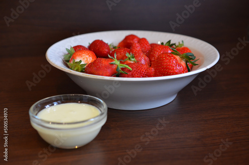 Ripe juicy strawberries with condensed milk