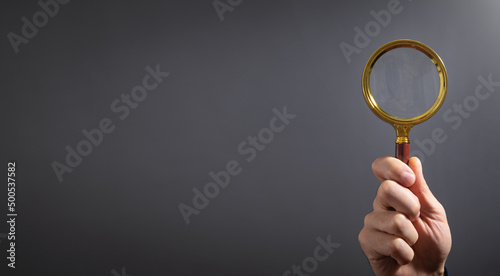 Caucasian businessman holding magnifying glass.