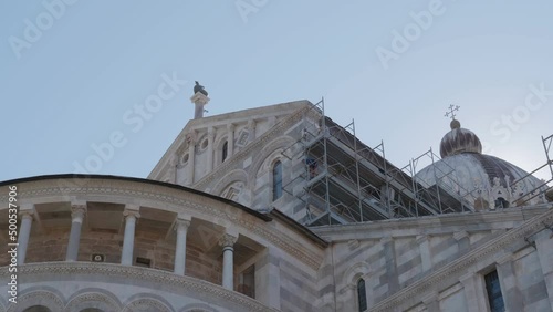 Construction workers working on high scaffold during facade renovations of a church in Pisa (Ialy) photo