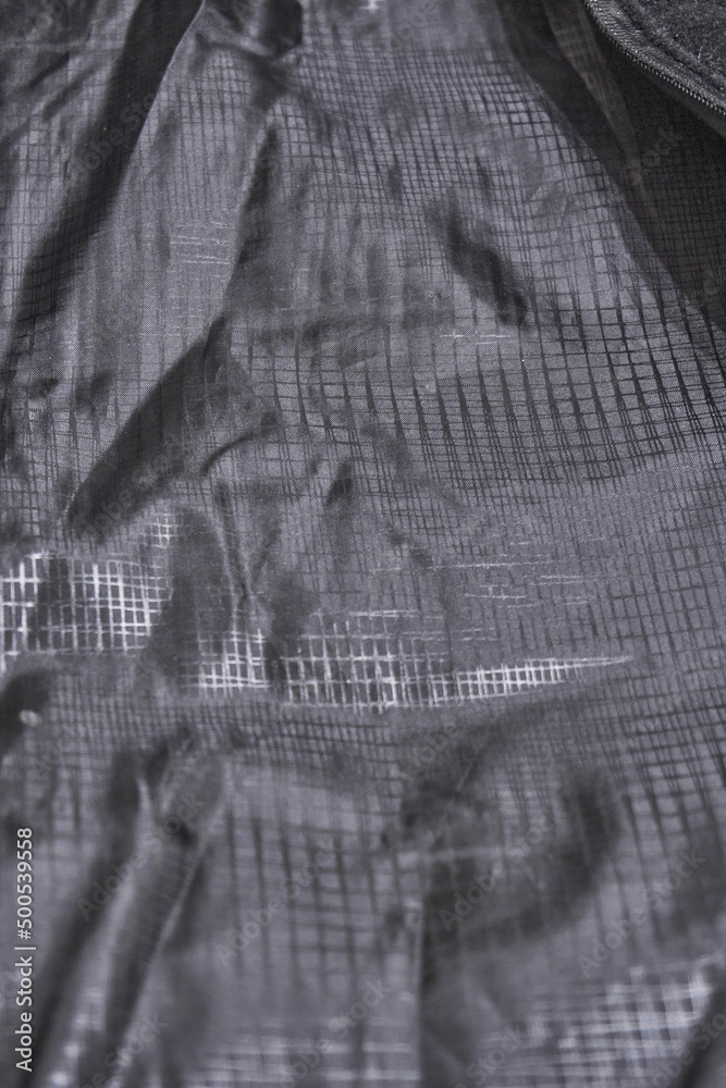 Black lining of clothes with texture. Polyester, folds. Soft selective selective focus. Clothing detail Black lining of clothes with texture. Polyester, folds. Soft selective selective focus. Clothing detail