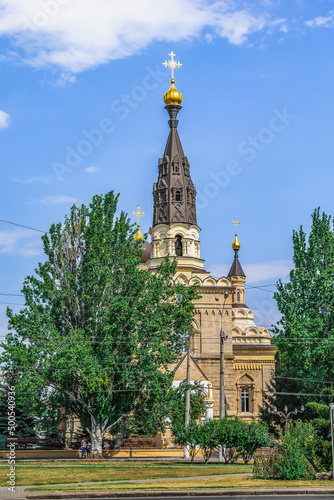 Mykolaiv, Ukraine - July 26, 2020: The building of the Cathedral of Our Lady Mother of Kasperovskaya in Mykolaiv among the greenery, vertical. Beautiful architecture of the Ukrainian Orthodox Church photo