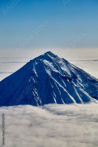 Mountain sunny landscape. Mountain peak over white thick clouds.