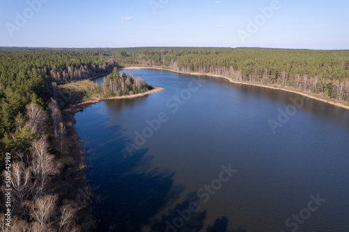 River, forest, natural environment from a bird's eye view in the morning. Low flying under trees, wildlife and nature in beautiful weather conditions.