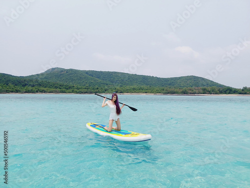  woman relaxing on a sup surfboard, floating on the clear turquoise sea water. Stand Up Paddle boarding. Summer fun, holidays travel. Active lifestyle