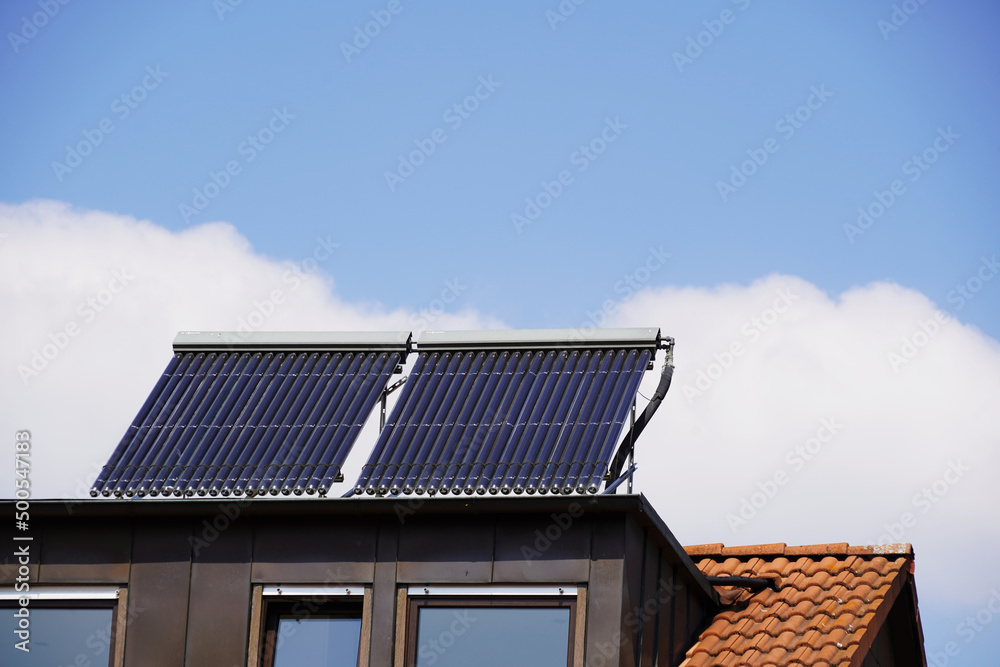 Solarthermie Anlage auf einer Dachgaube. Die Panele sind schräg gestellt um noch mehr Sonnenenergie aufnehmen zu können. DEr blaue Himmel mit einigen Schönwetter Wolken verspricht eine hohe Ausbeute Solarthermie Anlage auf einer Dachgaube. Die Panele sind schräg gestellt um noch mehr Sonnenenergie aufnehmen zu können. DEr blaue Himmel mit einigen Schönwetter Wolken verspricht eine hohe Ausbeute