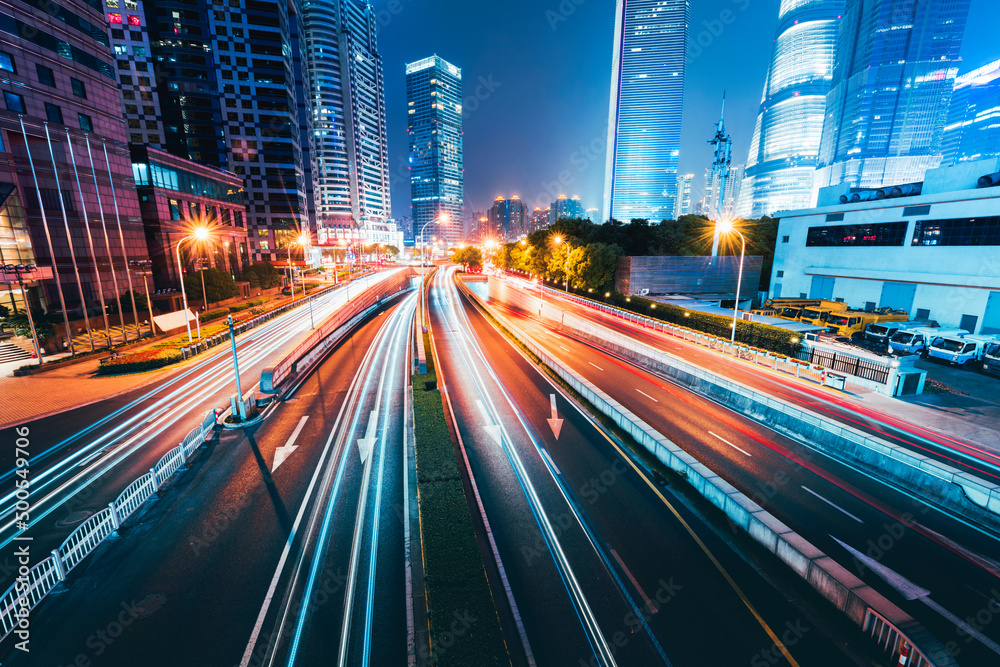 Buildings in the night view of the city and cars driving on the expressway