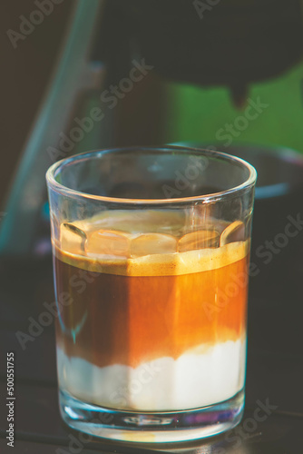 Coffee with milk in glass at camping tent.