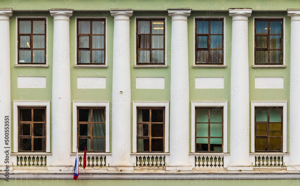 Obraz premium Columns and many windows in a row on the facade of the urban historic apartment building front view, Saint Petersburg, Russia 
