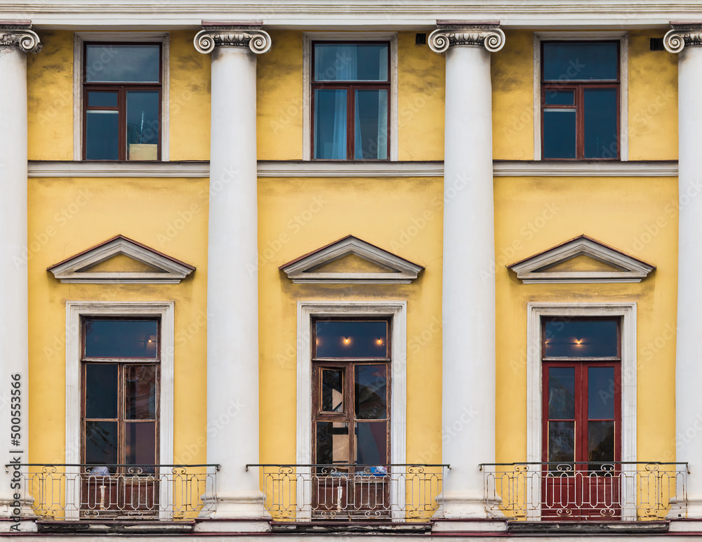 Obraz premium Columns and several windows in a row on the facade of the urban historic apartment building front view, Saint Petersburg, Russia 