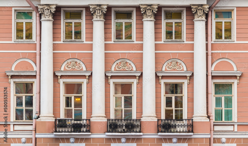 Naklejka premium Columns and many windows in a row on the facade of the urban historic apartment building front view, Saint Petersburg, Russia 