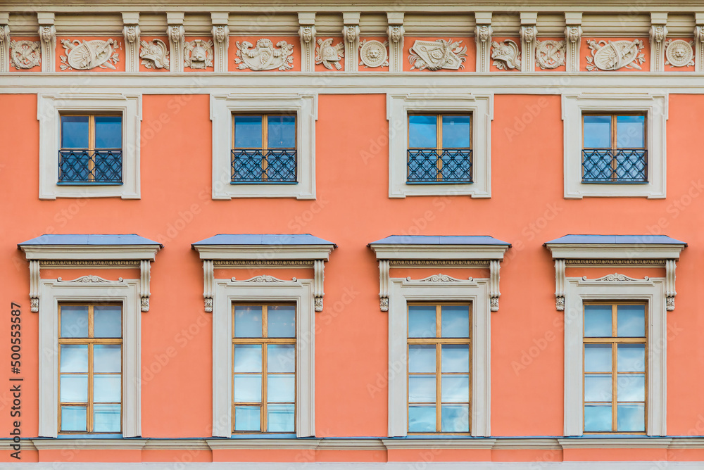 Fototapeta premium Several windows in a row on the facade of the urban historic apartment building front view, Saint Petersburg, Russia 