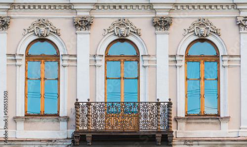 Balcony and three windows in a row on the facade of the urban historic apartment building front view, Saint Petersburg, Russia
