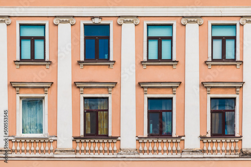 Several windows in a row on the facade of the urban historic apartment building front view, Saint Petersburg, Russia 