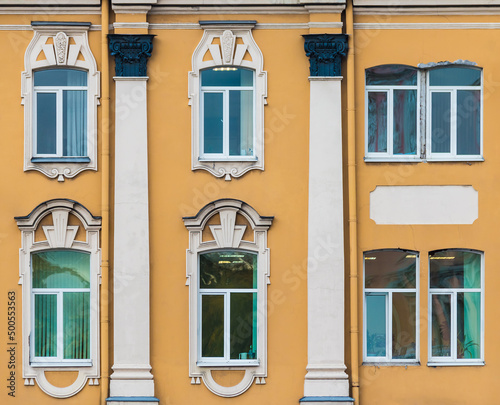 Several windows in a row on the facade of the urban historic apartment building front view, Saint Petersburg, Russia 