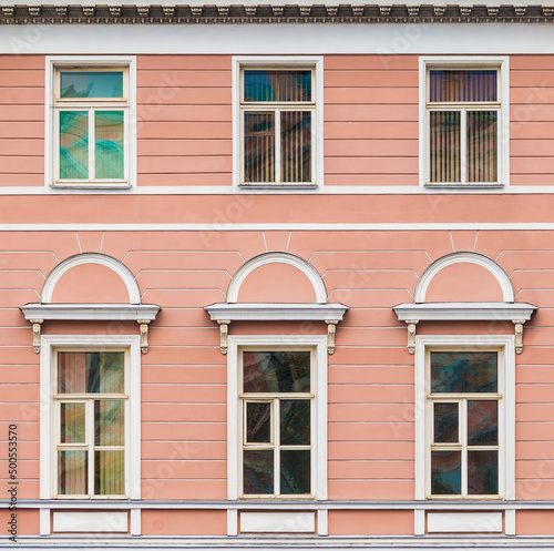 Several windows in a row on the facade of the urban historic apartment building front view, Saint Petersburg, Russia 