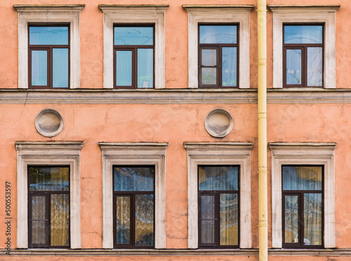 Several windows in a row on the facade of the urban historic apartment building front view, Saint Petersburg, Russia
