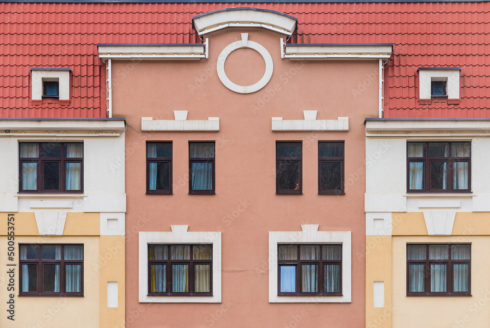 Fototapeta premium Many windows in a row on the facade of the modern urban apartment building front view, Krasnaya Polyana, Sochi, Krasnodar Krai, Russia 