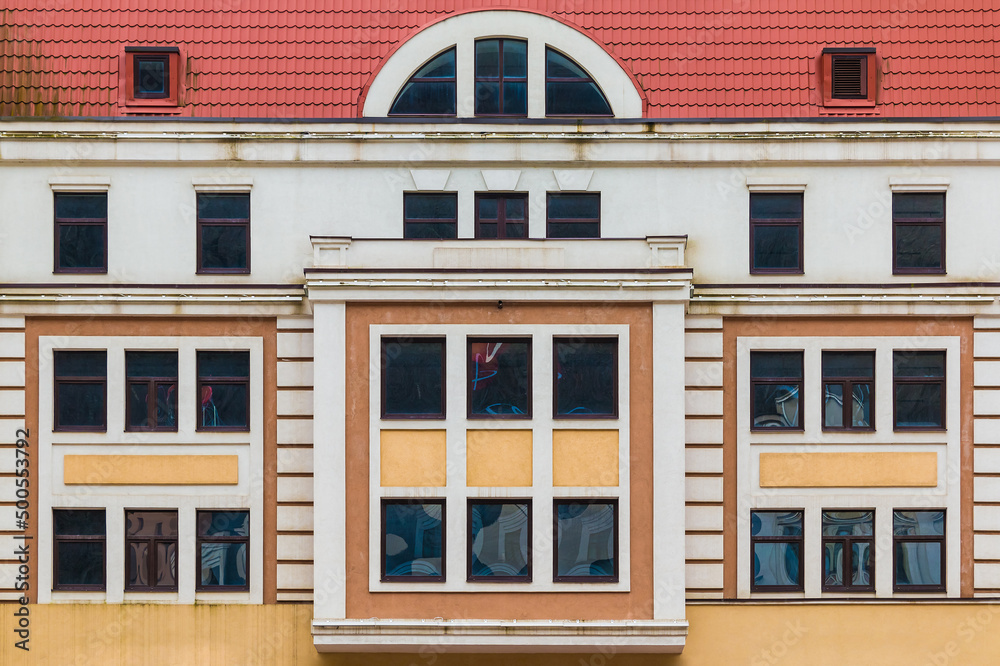 Fototapeta premium Many windows in a row on the facade of the modern urban apartment building front view, Krasnaya Polyana, Sochi, Krasnodar Krai, Russia 