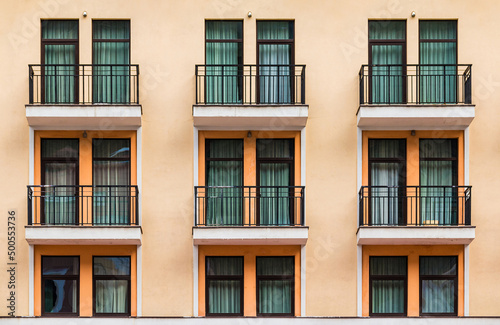 Many balconies and windows in a row on the facade of the modern urban apartment building front view, Krasnaya Polyana, Sochi, Krasnodar Krai, Russia 