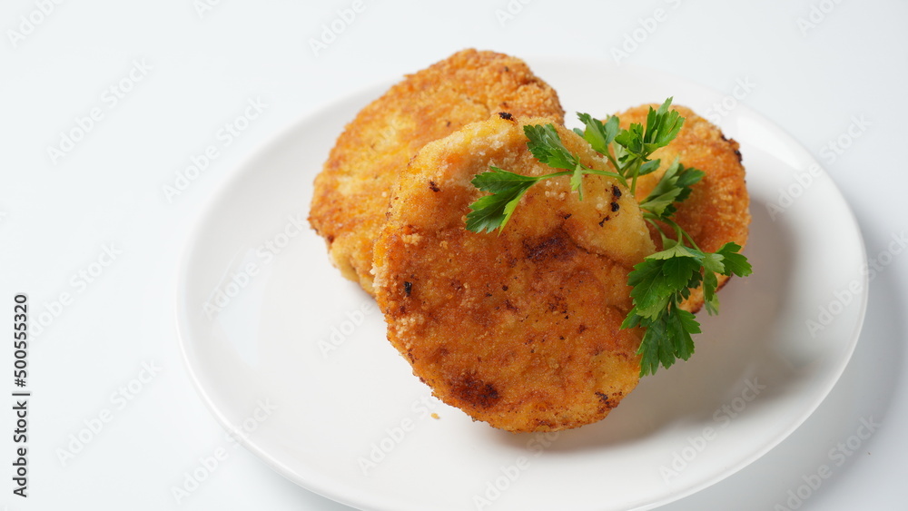 Plate with chicken cutlets. Fried juicy cutlets on a white plate garnished with parsley Plate with chicken cutlets. Fried juicy cutlets on a white plate garnished with parsley