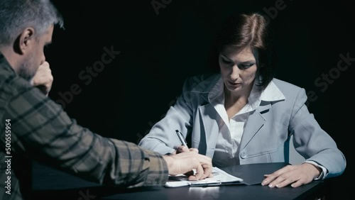 Male crime suspect giving money to investigator, female detective taking bribe photo
