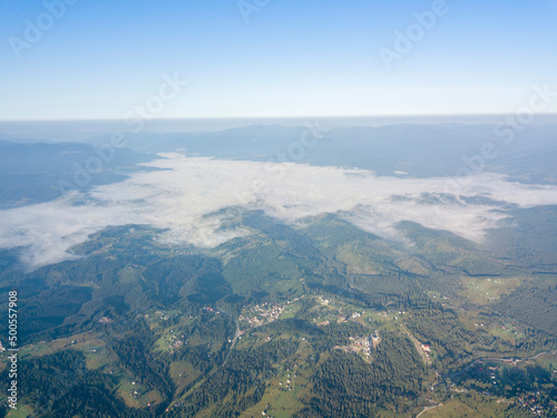 High flight in the mountains of the Ukrainian Carpathians. Fog in the valley. Aerial drone view.