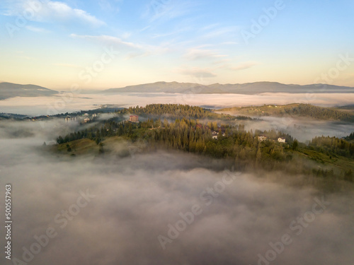 The rays of dawn over the fog in the Ukrainian Carpathians. Aerial drone view.