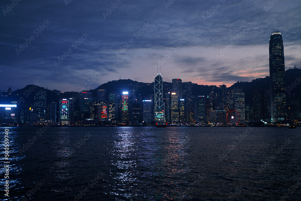 Fototapeta premium Central business district Hong Kong with a sunset dawn sky above the harbour at night time.