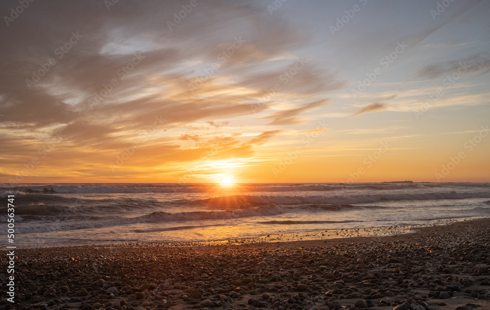 Obraz premium Horizontal shot of a colorful sunset at Concón beach with lens flare, Chile